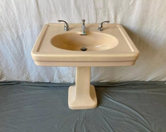 May include: A pedestal sink with a white porcelain basin and a chrome faucet. The sink is in a bathroom setting.