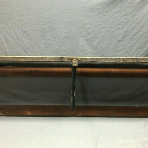 May include: A vintage wooden shelf with black metal brackets and a brown wooden rod. The shelf is painted black and has a distressed look.