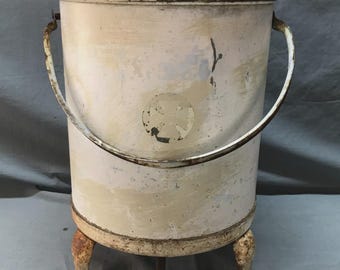 May include: An antique white metal Hygeia foot pedal trash can with a lid and handle. The can has a distressed finish, three decorative feet, and the word "Hygeia" on the pedal.