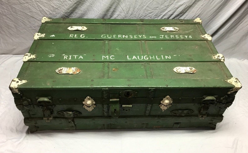 May include: A vintage green wooden trunk with metal hardware and white painted lettering that reads "REG. GUERNSEYS AND JERSEYS "RITA" MC LAUGHLIN -"