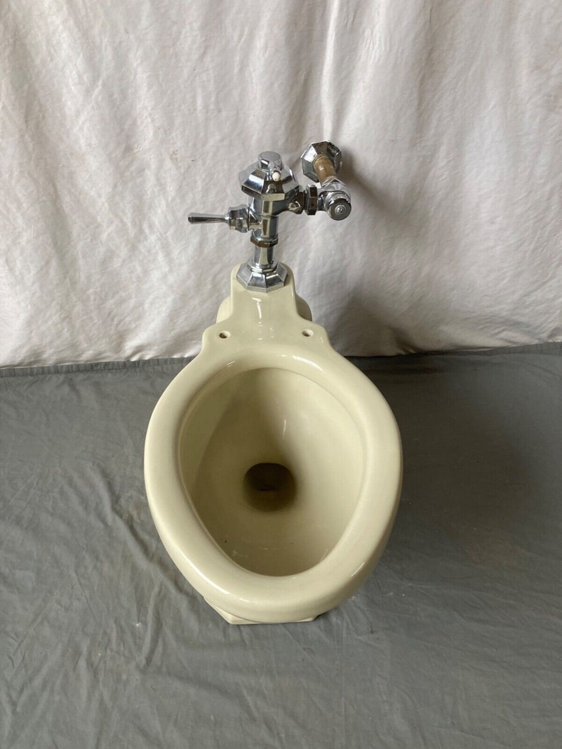 K&ouml;nnte beinhalten: Eine vintage Toilette in off-wei&szlig; mit einem verchromten Sp&uuml;lventil und einem Holzgriff.