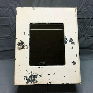 May include: White metal medicine cabinet with a mirrored door. The cabinet has a small knob and shows signs of wear and tear.