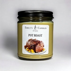May include: A glass jar candle with a brown label that says "Emily's Candles Est 2002 Pot Roast". The label also features a photo of a roasted pot roast with vegetables.