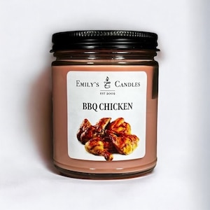 以下が含まれることがあります： ブラウンのラベルに「Emily's Candles Est 2002 BBQ Chicken」と書かれたガラス製のジャーキャンドル。ラベルには、グリルした鶏肉の画像も掲載されています。