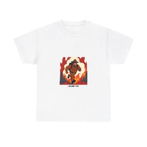 Può includere: T-shirt bianca con un'illustrazione di un orso di cartone animato che indossa un cappello da ranger e corre attraverso un incendio boschivo. Il testo "I blame you." è stampato sotto l'immagine.