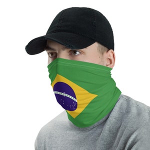 Pu&ograve; includere: Una persona indossa un cappello da baseball nero e una copertura per il viso con la bandiera brasiliana stampata su di essa. La bandiera &egrave; verde, gialla, blu e bianca con un cerchio al centro che dice "Ordem e Progresso".