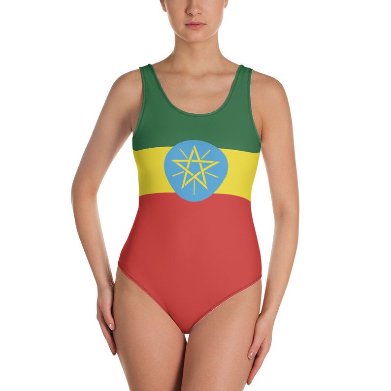 Puede incluir: Un traje de ba&ntilde;o de una pieza con la bandera de Etiop&iacute;a. El traje de ba&ntilde;o es verde, amarillo y rojo con una estrella azul en el centro de la franja amarilla.
