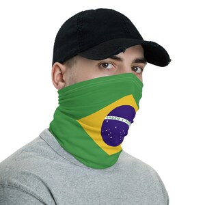 Pu&ograve; includere: Una maschera facciale verde, gialla e blu con la bandiera brasiliana stampata su di essa. La bandiera presenta un cerchio blu con stelle bianche e il testo "ORDEM E PROGRESSO".