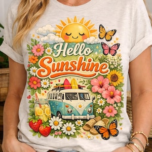 Peut inclure: T-shirt gris clair avec un motif coloré. Le motif représente un soleil souriant, des papillons, des fleurs, un van vintage avec des planches de surf et l'inscription "Hello Sunshine". Le t-shirt est de style décontracté et estival.