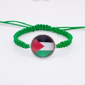 May include: Green macrame bracelet featuring a round charm with the Palestinian flag. The bracelet has a sliding knot closure for adjustable sizing. The text "AVAILABLE IN MORE COLORS!" is displayed in red.