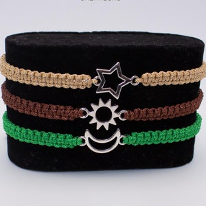 May include: Three macrame bracelets with star, sun, and moon charms. The bracelets are in green, brown, and gold.  Available in 13 colors.