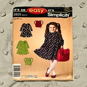 May include: A Simplicity sewing pattern envelope, number 2825, size A 3-8. The front features illustrations of a long-sleeved dress and a backpack, with a photograph of a child wearing the floral dress and holding a red bag. Text includes IT'S SO easy IT'S Simplicity.