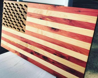 Op de afbeelding: Een Amerikaanse houten vlag met rode en witte strepen. De vlag is gemaakt van cederhout en heeft een ontwerp van messing kogelhulzen in het blauwe veld.