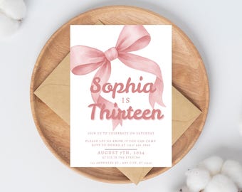 May include: A birthday invitation featuring a watercolor-style pink bow and the text "Sophia is Thirteen." The invitation is on a white background, placed on a wooden plate with a brown envelope. Additional text includes event details.
