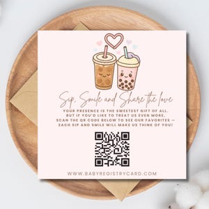 Könnte beinhalten: Hellrosa Karte mit zwei Cartoon-Bubble-Tea-Getränken, einem Herz und dem Text "Sip, Smile and Share the love". Die Karte enthält einen QR-Code und die Website www.babyregistrycard.com. Die Karte liegt auf einem Holztablett.