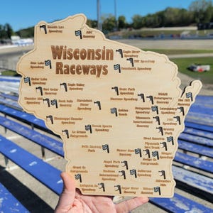 May include: Wooden map of Wisconsin with the text "Wisconsin Raceways" and small checkered flags marking the locations of various speedways. The map is held by a person.