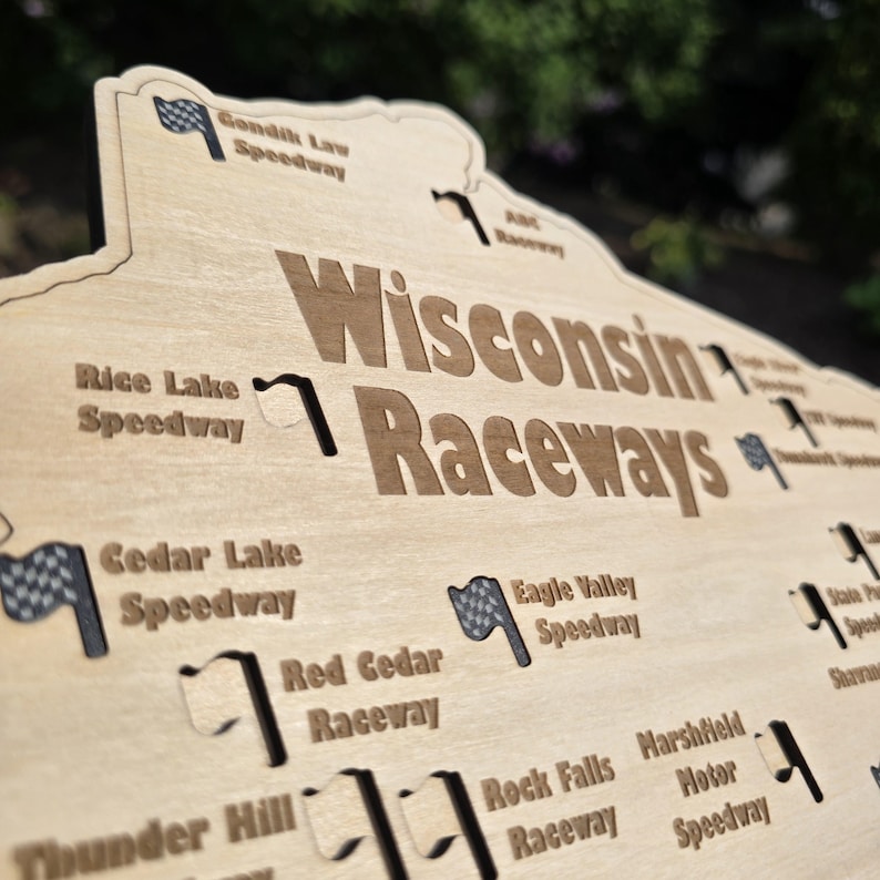 May include: Wooden sign featuring the words "Wisconsin Raceways" in a bold font. The sign is shaped like the state of Wisconsin and includes the names of various speedways, along with checkered flag graphics.