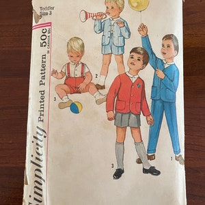 Op de afbeelding: Vintage Simplicity patroon-envelop. De omslag toont illustraties van vier jonge kinderen in verschillende outfits, waaronder een gestreept pak, een rode jas en een blauw pak. De tekst op de envelop luidt "4913 Toddler Size 3" en "Printed Pattern".