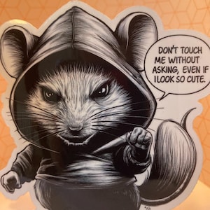 Könnte beinhalten: Schwarzweiß-Illustration einer Maus, die einen Kapuzenumhang trägt und ein Messer hält. Die Maus hat einen ernsten Ausdruck und der Text "Fass mich nicht an, ohne zu fragen, selbst wenn ich so süß aussehe." befindet sich in einer Sprechblase.