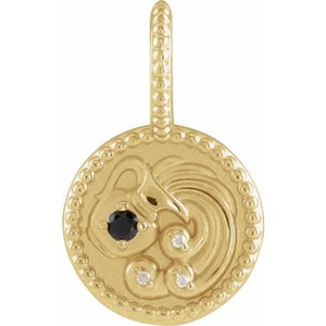 May include: Gold zodiac pendant featuring the Aquarius constellation with a black gemstone and three smaller white gemstones. The pendant is round and has a beaded border.