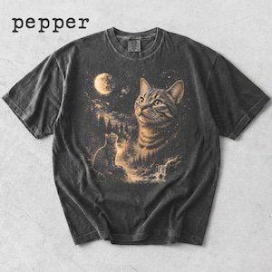 Op de afbeelding: Een antracietgrijs t-shirt met korte mouwen en een grafische print van een grote kattenkop, een kleine kat zittend op een rots, een volle maan, een bos en een waterval. Het woord pepper staat gedrukt in de linkerbovenhoek van het kledingstuk.