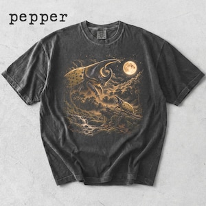 Może przedstawiać: Ciemnoszary t-shirt z nadrukiem graficznym przedstawiającym dwa duże chrząszcze nosorożce w leśnym krajobrazie pod pełnią księżyca. Słowo pepper jest nadrukowane w lewym górnym rogu. Koszulka ma okrągły dekolt i krótkie rękawy.