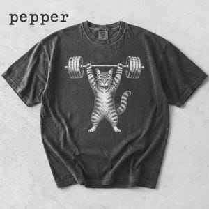 Könnte beinhalten: Dunkelgraues T-Shirt mit einem weißen und grau gestreiften Kater, der eine Langhantel stemmt. Das Wort "pepper" ist oben links in Weiß aufgedruckt. Die Katze trägt ein Stirnband. Ein lässiges, bequemes T-Shirt.