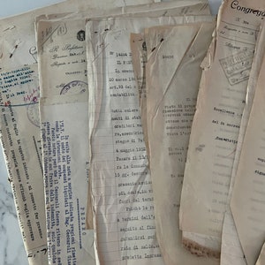 May include: A stack of old, yellowed papers with handwritten text and typed text. The papers are stacked on top of each other and some are folded. The text on the papers is in Italian.