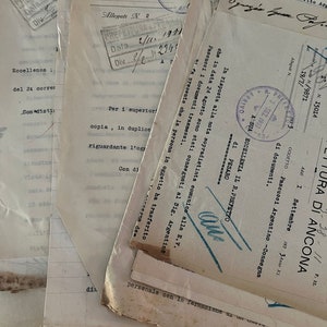 May include: A stack of old, yellowed documents with handwritten text and official stamps. The documents are in Italian and include the words "Eccellenza", "Allegati", "Prefetto", and "Pesaro".