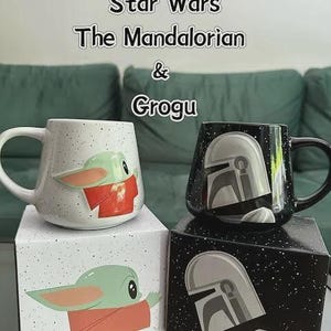Puede incluir: Dos tazas de cer&aacute;mica de Star Wars The Mandalorian & Grogu. Una taza blanca moteada muestra a Grogu con t&uacute;nica roja, mientras que la otra taza negra moteada muestra un casco mandaloriano. Cada taza se apoya sobre su caja ilustrada.