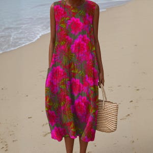 May include: Sleeveless dress with a vibrant floral pattern in shades of pink and green. The dress has a relaxed fit and pockets. A woven straw tote bag is held in the hand. The dress is knee-length and suitable for warm weather.
