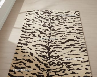 May include: Rectangular area rug with a tiger stripe pattern in cream and dark brown. The rug is placed on a light wood floor, with a window and wall in the background. The rug's design resembles tiger fur.