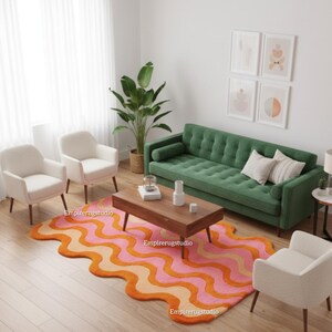 May include: A living room scene featuring a green sofa, two white armchairs, and a wooden coffee table. A colorful rug with wavy orange and pink patterns sits on the floor. Decorative artwork hangs on the wall, and a large plant is in the background.
