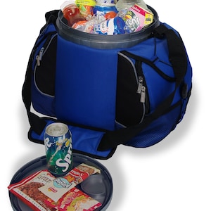 May include: A blue and black insulated cooler bag with a circular lid that doubles as a tray. The bag is filled with various beverage bottles and cans. The detached lid sits in front, holding a Sprite can, a granola bar, and a snack package.