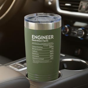 May include: An olive green stainless steel tumbler with a clear lid. The exterior features white text reading ENGINEER Nutrition Facts, listing percentages for Critical Thinking, Wrong Answers, Caffeine, Nerdiness, Innovation, and Attention to Detail.