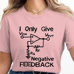Puede incluir: Camiseta rosa con un gráfico negro de un circuito amplificador operacional con el texto "I Only Give Negative Feedback".