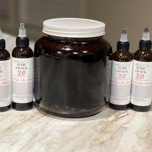 以下が含まれることがあります： 白いラベルに「Hair Crack 2.0」と書かれた濃い茶色の液体の入ったボトルが4本と、同じ液体の入った大きな瓶。