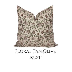 May include: A tan and olive green throw pillow with a floral pattern. The pillow has a rust colored floral design.