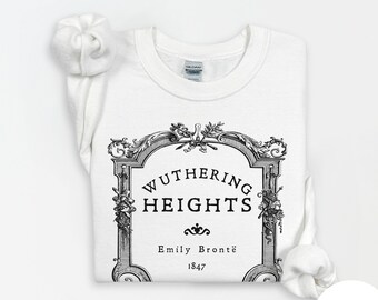 May include: White crew neck sweatshirt featuring a decorative black and white graphic. The graphic reads "Wuthering Heights" with the author's name and the year 1847. The sweatshirt is folded.