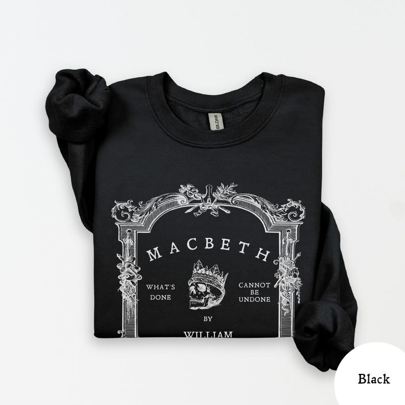 May include: Black sweatshirt featuring a white graphic design from Shakespeare's play, Macbeth. The design includes the title, a skull wearing a crown, and the phrases "What's Done" and "Cannot Be Undone". The author's name, William, is also included.