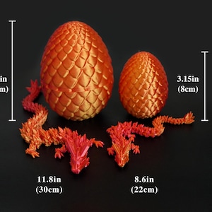 Pu&ograve; includere: Due uova di drago arancioni, una alta 13 cm e l'altra alta 8 cm, con figure di drago abbinate. Il drago pi&ugrave; grande &egrave; lungo 30 cm e il pi&ugrave; piccolo 22 cm. Le uova hanno una superficie strutturata e squamosa.