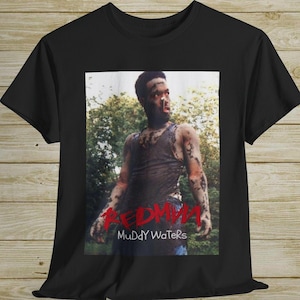 May include: Black t-shirt with a photo of a man covered in mud. The text "REDMAN" and "Muddy Waters" is printed in red on the shirt.