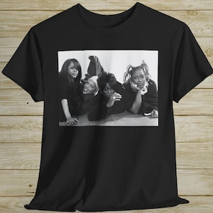 May include: Black and white photograph of four women posing for a picture. The women are wearing casual clothes and are looking at the camera.