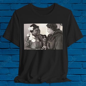 Può includere: Foto in bianco e nero di due donne, una delle quali tiene una statuetta degli Oscar. La donna a sinistra indossa un abito floreale e la donna a destra indossa un cappotto di pelliccia.