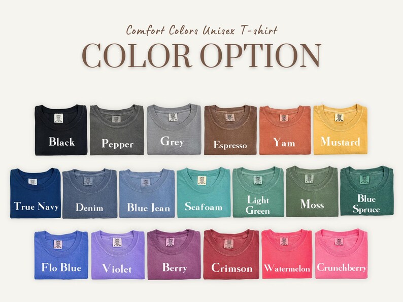 K&ouml;nnte beinhalten: Eine Auswahl an Comfort Colors Unisex-T-Shirts in verschiedenen Farben, darunter Schwarz, Grau und Blau. Das Bild zeigt die verf&uuml;gbaren Farboptionen mit Namen wie "Senf", "Seafoam" und "Berry" unter jedem Shirt.