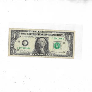 May include: A United States one-dollar bill featuring a portrait of George Washington in the center, the text THE UNITED STATES OF AMERICA, FEDERAL RESERVE NOTE, and ONE DOLLAR, with green serial numbers L17761946C and a green Treasury seal.