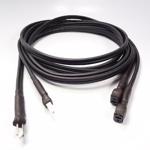 May include: A black power cable with a standard three-pin plug and two female connectors. The cable is coiled and appears to be made of a flexible, durable material. The connectors are dark brown.