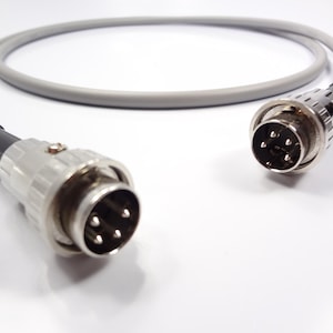 May include: A gray cable with two 5-pin connectors. The connectors are silver and have a black rubber ring around the base.