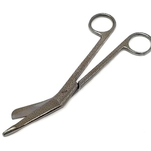 May include: A pair of silver surgical scissors with a curved blade and a textured handle.
