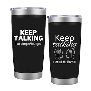 May include: Two black stainless steel tumblers with a white design. The tumbler on the left says "Keep Talking I'm diagnosing you". The tumbler on the right says "Keep talking I am diagnosing you" with a stylized image of two brains connected by a line.